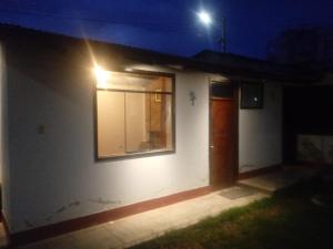 - une petite maison blanche avec fenêtre la nuit dans l'établissement El amanecer, à Cajamarca