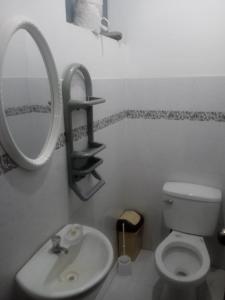 y baño con lavabo, espejo y aseo. en El amanecer, en Cajamarca