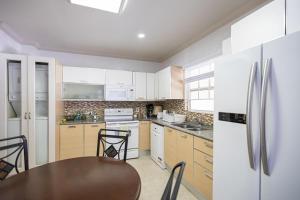 a kitchen with a table and a refrigerator at Whitesands G4 by Barbados Sothebys International Realty in Saint Peter