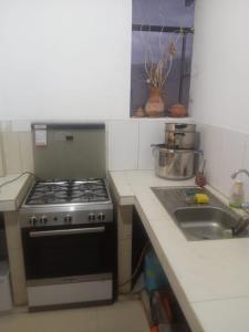 a kitchen with a stove and a sink at El amanecer in Cajamarca