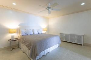 a bedroom with a bed and a ceiling fan at Whitesands G4 by Barbados Sothebys International Realty in Saint Peter