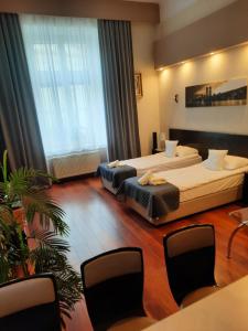 Una habitación de hotel con dos camas y una mesa y sillas. en Luxury Senate Apartment, en Cracovia 34 fotos más