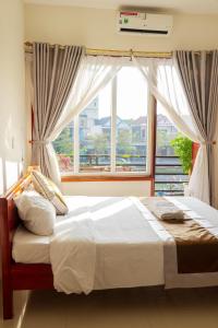 um quarto com uma cama e uma janela grande em Khách sạn 68 ĐỒNG HẢI em Dong Hoi
