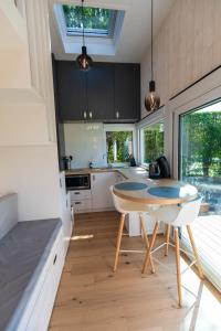 uma cozinha com mesa e cadeiras num quarto em Tiny house avec vue sur les étoiles em Jalhay
