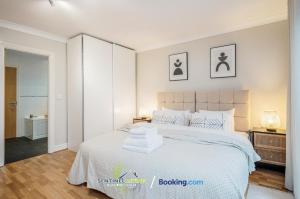 a bedroom with a white bed with towels on it at Pet Friendly Spacious Townhouse By Sentinel Living Short Lets & Serviced Accommodation Windsor Ascot Maidenhead With Free Parking in Winkfield