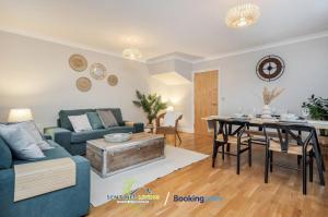 a living room with a blue couch and a table at Pet Friendly Spacious Townhouse By Sentinel Living Short Lets & Serviced Accommodation Windsor Ascot Maidenhead With Free Parking in Winkfield