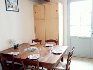 een eettafel met stoelen en een houten tafel en een stoeltje bij Maison La Flotte, 3 pièces, 6 personnes - FR-1-544-23 in La Flotte