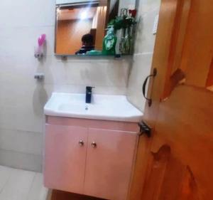 uma casa de banho com um lavatório branco e um espelho. em Room Stylish 1BHK em Islamabad