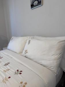 a bed with white pillows with flowers on it at Luxe Heights Nest in Birmingham