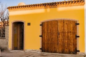 ein gelbes Haus mit einer großen Holztür in der Unterkunft La Loggia in Comacchio