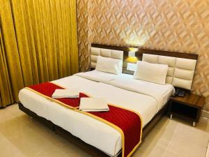 a bedroom with a large bed with two towels on it at Royal Indraprastha The Hotel in Bengaluru