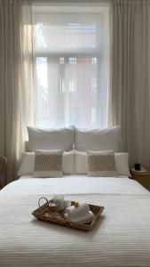 Cama blanca con bandeja con toalla y ventana en Traumhaftes City Apartment en Viersen