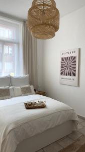 1 dormitorio con 1 cama blanca grande con lámpara de araña en Traumhaftes City Apartment en Viersen