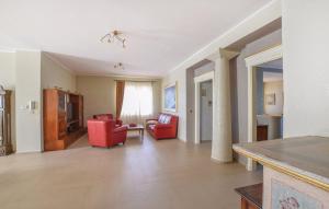 una sala de estar con 2 sillas rojas y una mesa. en Villa Martino, en Cassano Jonio
