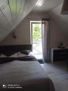 1 dormitorio con 1 cama y puerta corredera de cristal en Całoroczny Ośrodek Wypoczynkowy COMFORT HOUSE, en Duszniki-Zdrój