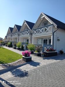 una fila de casas con flores en un patio en Całoroczny Ośrodek Wypoczynkowy COMFORT HOUSE, en Duszniki-Zdrój