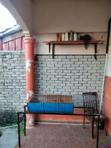 a bed sitting in a room with a brick wall at Inapan Salsabila in Jitra
