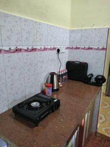 a kitchen counter with a stove on a counter top at Inapan Salsabila in Jitra