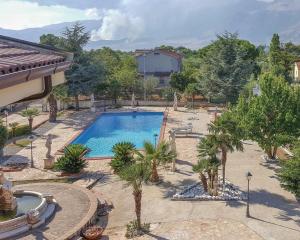 uma grande piscina com palmeiras e um edifício em Villa Martino em Cassano Jonio
