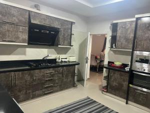 a kitchen with black cabinets and appliances in a room at Thurayya&zaheed luxury in Abuja