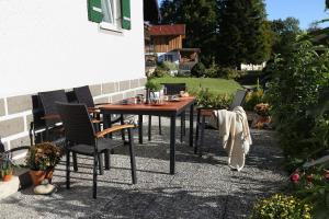 a wooden table and chairs on a patio at Ferienhaus Murmel in Ruhpolding