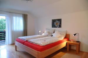 a bedroom with a bed with a red and white comforter at Ferienhaus Murmel in Ruhpolding