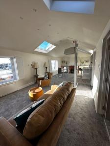 uma sala de estar com um sofá castanho e uma sala de estar em Riverside Seaside Apartment em Littlehampton