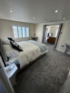 a bedroom with a large bed and a mirror at Riverside Seaside Apartment in Littlehampton