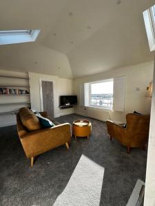 a living room with two couches and a tv at Riverside Seaside Apartment in Littlehampton