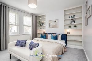 a bedroom with a bed and a white chair at Beautiful 3 BDR House in Windsor Town By Sentinel Living Short Lets & Serviced Accommodation Windsor Ascot Maidenhead With Pet Friendly & Superfast Wifi in Windsor