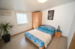 Un dormitorio con una cama y una planta. en Apartment Delphin, en Vir