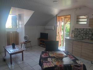een woonkamer met een tafel en een keuken bij Ti Cozy in Baie-Mahault