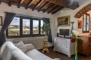 a living room with a couch and a tv on a dresser at Il Saragio in Abbadia di Montepulciano