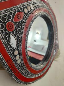 a mirror sitting on top of a red purse at Maison d'hôtes Retour Au Calme in Tinerhir