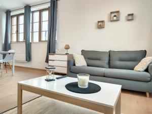 a living room with a couch and a coffee table at Le Pampas - ZMN Conciergerie in Saint-Quentin