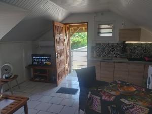 een keuken met een bank en een tafel in een kamer bij Ti Cozy in Baie-Mahault