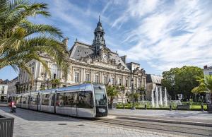 een bus die voor een gebouw rijdt bij Très beau studio quartier Cathédrale bord de Loire in Tours