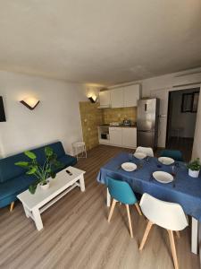 un soggiorno con tavolo blu e divano blu di Le Mirage Ibiza a San Antonio