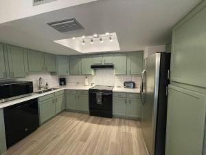 a kitchen with green cabinets and black appliances at *Msg for 5%off*3Bed2Bath KingQueenTwins 4Beds PHX in Phoenix