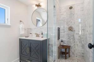 ein Bad mit einem Waschbecken und einer Dusche mit einem Spiegel in der Unterkunft Alpine Estate 3 Kitchens & Mountain Views in Buena Vista