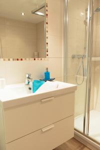 a bathroom with a white sink and a shower at Appartement Wöhrer in Schladming