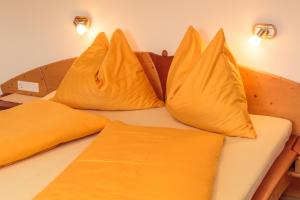 een bed met gele kussens erop bij Appartement Wöhrer in Schladming