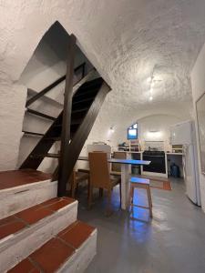 a kitchen and dining room with a table and a staircase at Cassano, Maison de village 4/6 personnes à 15mn de Calvi in Cassano