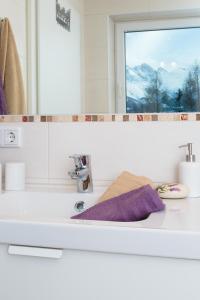 a bathroom sink with a mirror and a purple towel at Appartement Wöhrer in Schladming