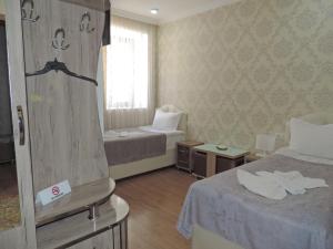 a hotel room with two beds and a window at Hotel Lotus in Akhaltsikhe
