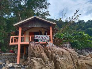 ein kleines Gebäude mit einem Schild auf einem Felsen in der Unterkunft Mama's Bungalows Koh Chang Ranong in Koh Chang Ranong