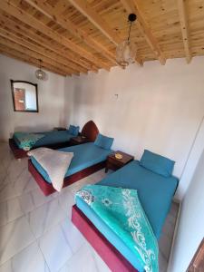 two beds in a room with wooden ceilings at Badya Camp Dahab in Dahab