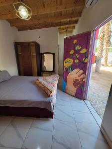 a bedroom with a bed and a painting on the wall at Badya Camp Dahab in Dahab