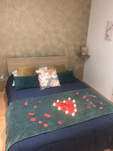 een bed met rode harten op een groene deken bij Chez Sophie in Altviller