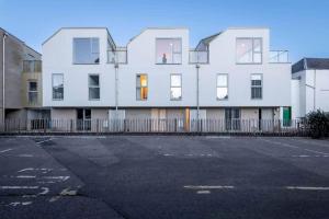 a white building with a parking lot in front of it at Argyle Rigg - Central Elegant Townhouse - Balcony in St. Andrews